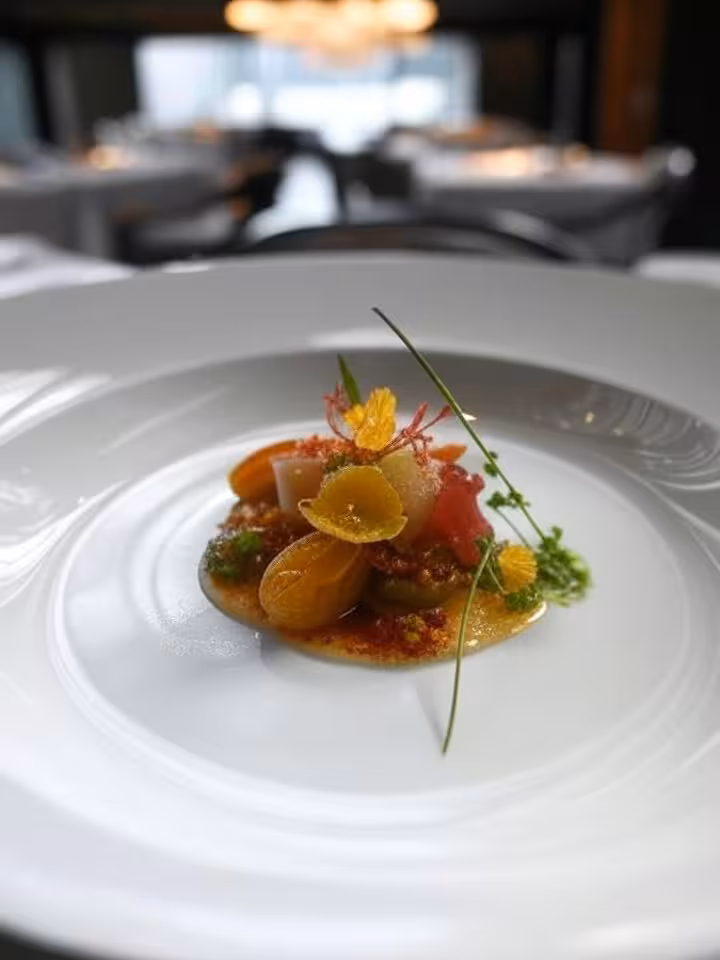 Piatto gourmet artisticamente presentato in un ristorante stellato con impiattamento raffinato